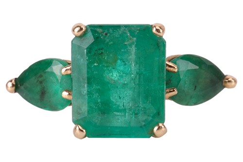 Lot 14 - An emerald trilogy ring, centred with a...