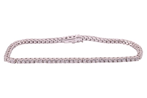 Lot 143 - A diamond line bracelet in 18ct white gold,...