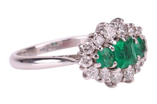 Lot 45 - An emerald and diamond cluster ring in 18ct...
