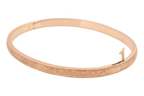 Lot 56 - De Beers - a hinged bangle in 18ct yellow gold,...