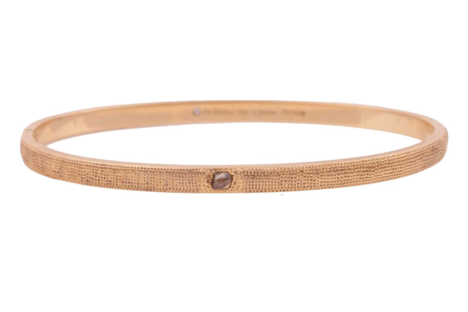 Lot 56 - De Beers - a hinged bangle in 18ct yellow gold,...
