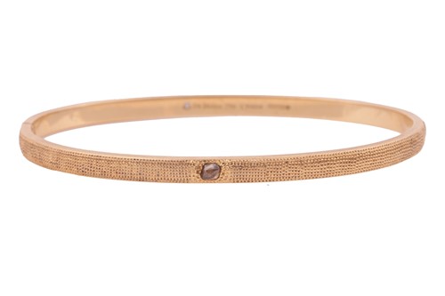 Lot 56 - De Beers - a hinged bangle in 18ct yellow gold,...