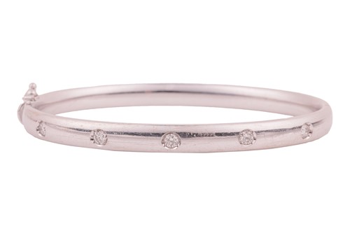 Lot 85 - A diamond-set hinged bangle, the court-shaped...