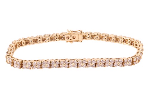 Lot 193 - A diamond line bracelet in 18ct yellow gold,...