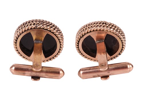 Lot 33 - A pair of onyx-set cufflinks, each containing...