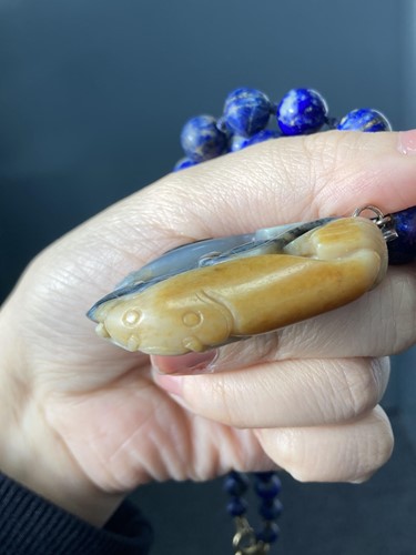 Lot 35 - A Chinese carved nephrite pendant on a lapis...