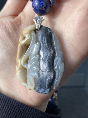 Lot 35 - A Chinese carved nephrite pendant on a lapis...