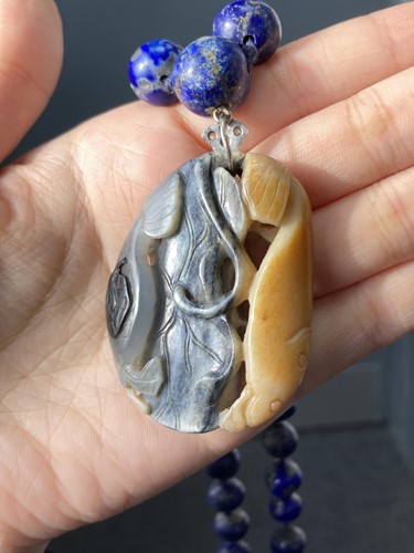 Lot 35 - A Chinese carved nephrite pendant on a lapis...