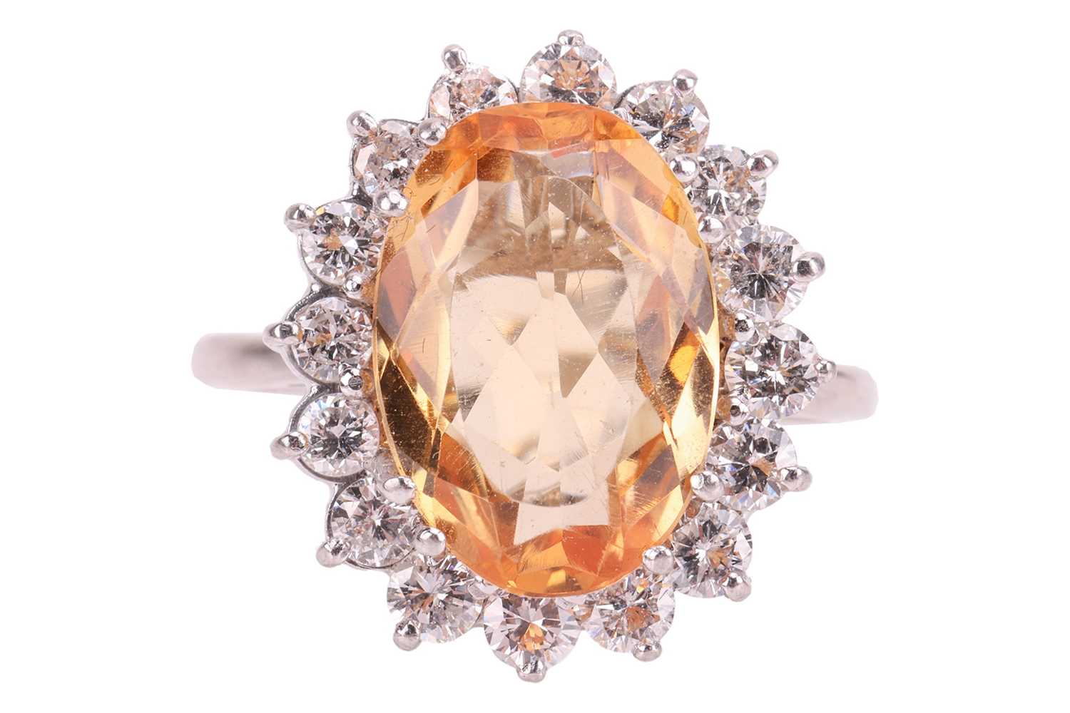 Lot 19 - A topaz and diamond halo ring, centred with an...