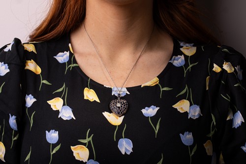Lot 100 - A sapphire and diamond heart-shaped locket on...