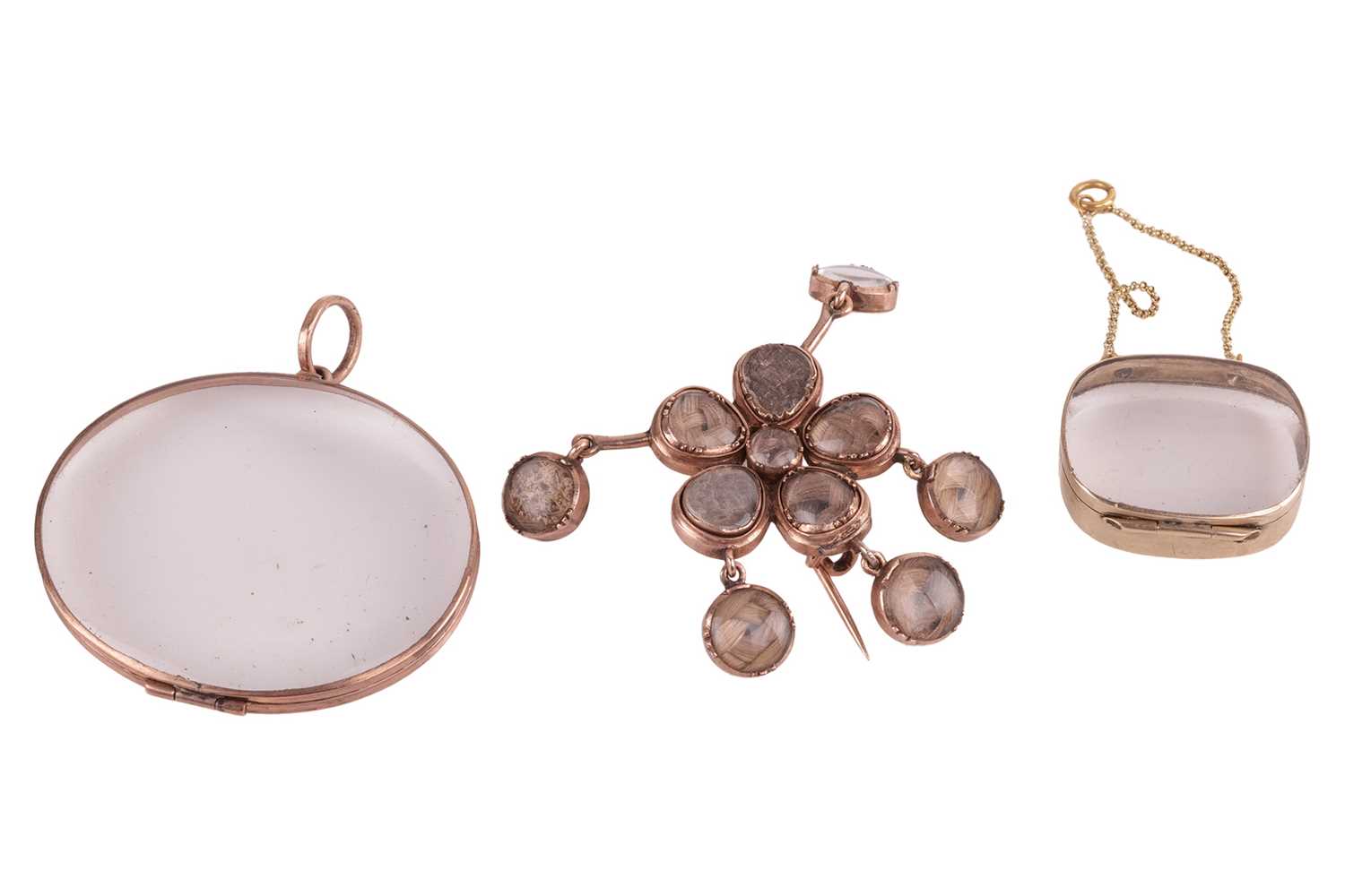 Lot 136 - A floral mourning brooch and two glass lockets;...