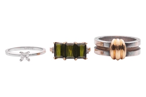 Lot 50 - A group of three rings; to include a solitaire,...