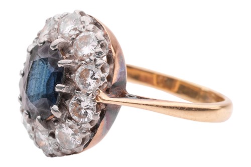 Lot 28 - A sapphire and diamond cluster ring, centred...