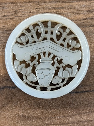 Lot 60 - A Chinese carved grey/green jade disk amulet...