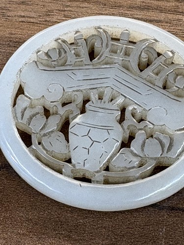Lot 60 - A Chinese carved grey/green jade disk amulet...