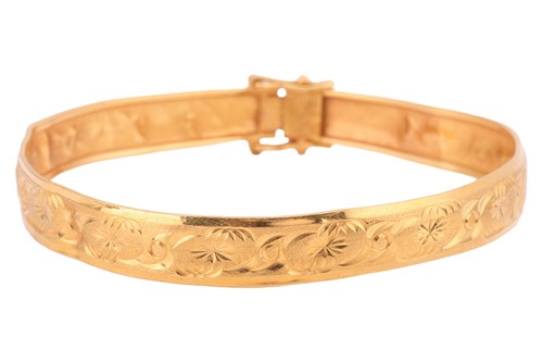 Lot 33 - A bangle engraved with foliate design, the...