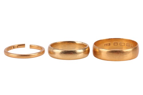 Lot 29 - Three 22ct gold band rings, one 5.95mm wide,...