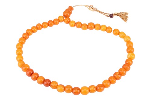 Lot A string of amber 'prayer' or 'worry' beads;...