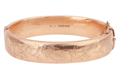 Lot A 9ct gold hollow bangle, the front engraved...