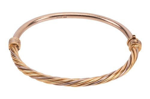Lot A hinged bangle in 18ct bi-coloured gold, half...