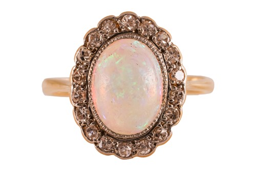 Lot 213 - An opal and diamond halo ring, centred with an...