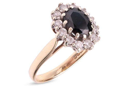 Lot 84 - A sapphire and diamond halo ring in 9ct gold,...
