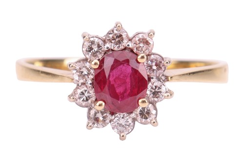 Lot 16 - A ruby and diamond halo ring, centred with an...