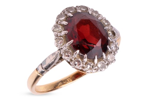 Lot A garnet and diamond halo ring, centred with...