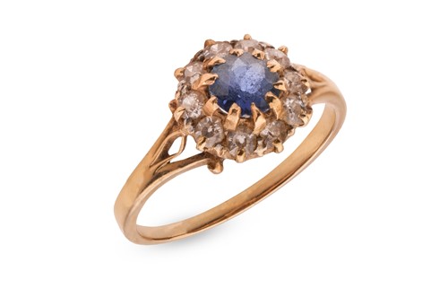 Lot 227 - A sapphire and diamond cluster ring, claw-set...