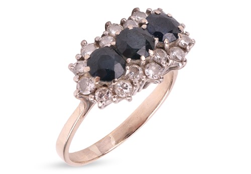 Lot 130 - A three-stone sapphire and diamond cluster...