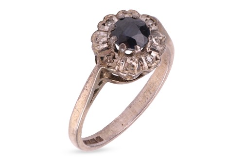Lot 229 - A sapphire daisyhead ring in silver, centred...