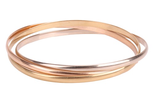Lot 232 - Cartier – a trinity bangle in 18ct gold,...