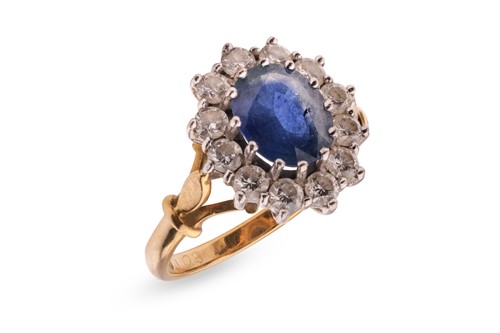 Lot 73 - A sapphire and diamond cluster ring, centred...