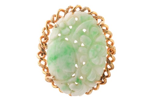 Lot A carved jade brooch, the oval jade plaque...
