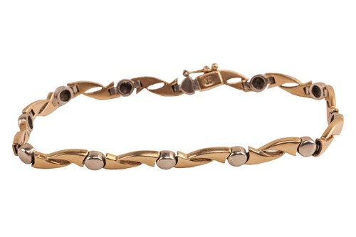 Lot 185 - A two-toned link bracelet, the hinged links...