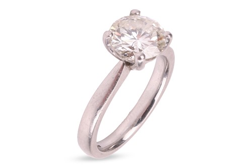 Lot 286 - A diamond solitaire ring in platinum, a round...