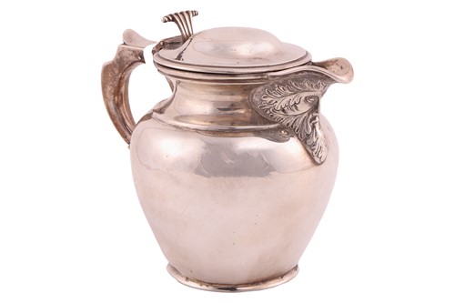 Lot 445 - A silver pot-bellied water jug with a hinged...