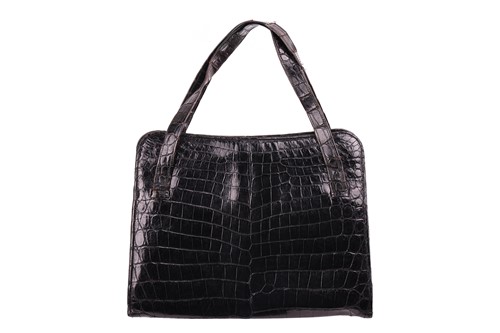Lot 102 - Cartier - a handbag in black crocodile skin...