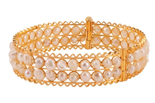 Lot 227 - A pearl set openwork bangle; of hinged oval...