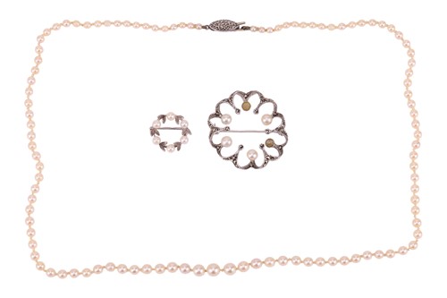 Lot A cultured pearl necklace and two brooches;...
