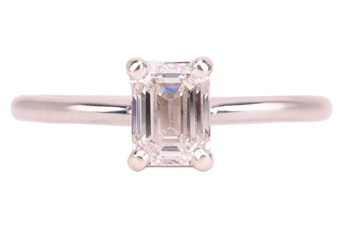 Lot An emerald-cut diamond solitaire ring in 14ct...