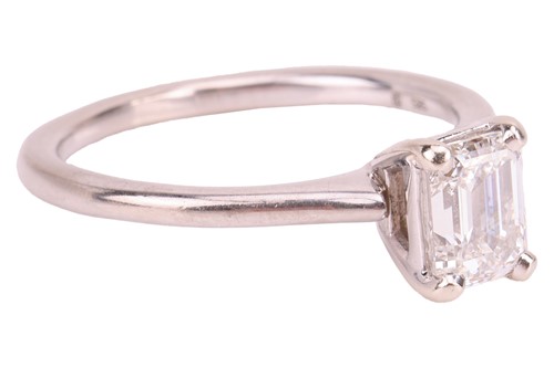 Lot An emerald-cut diamond solitaire ring in 14ct...