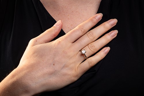 Lot 40 - An emerald-cut diamond solitaire ring in 14ct...