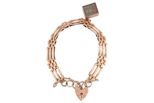Lot A gate link bracelet in 9ct gold, suspending...