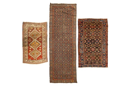 Lot 163 - An antique tomato red ground Kazak rug with...