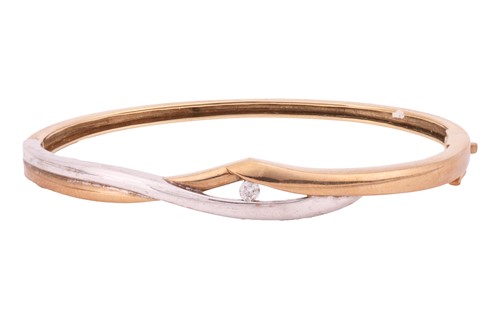 Lot 45 - A two-toned hinged bangle in 9ct gold, tension-...