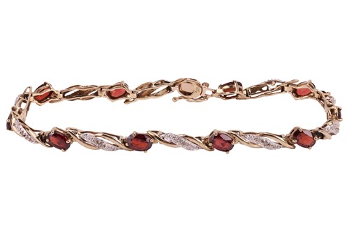 Lot 86 - A garnet and diamond line bracelet in 9ct gold,...