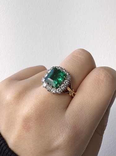 Lot 82 - A Colombian emerald and diamond cluster ring,...