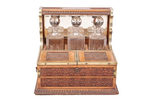 Lot A Victorian oak three-bottle tantalus, with...