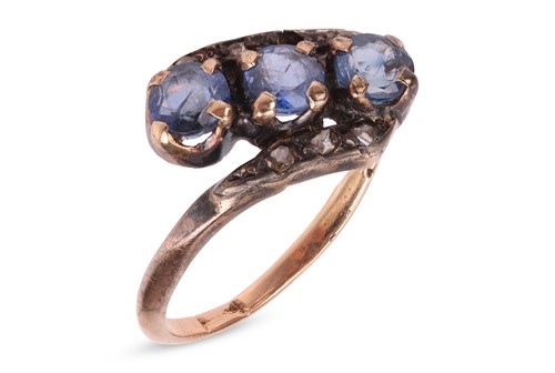 Lot A sapphire crossover ring, claw-set with three...